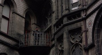 Movie still from “In the Name of the Father” (1993), directed by Jim Sheridan – A man standing on a balcony of an old building; Extreme Wide shot, Low angle