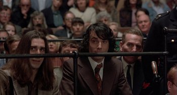 Movie still from “In the Name of the Father” (1993), directed by Jim Sheridan – A group of people sitting in front of a crowd; Medium shot, Low angle