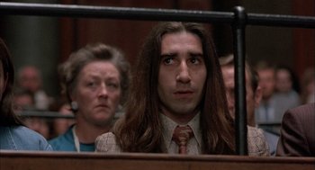 Movie still from “In the Name of the Father” (1993), directed by Jim Sheridan – A man with long hair is sitting next to a woman; Close Up shot, Low angle
