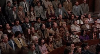 Movie still from “In the Name of the Father” (1993), directed by Jim Sheridan – A group of people sitting in a room; Wide shot, High angle
