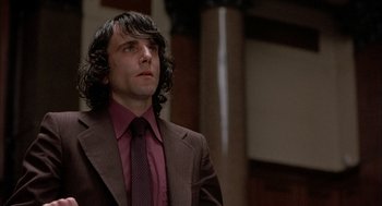 Movie still from “In the Name of the Father” (1993), directed by Jim Sheridan – A man in a brown suit and a red tie; Close Up shot, Low angle