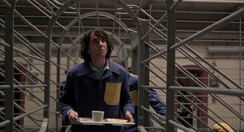 Movie still from “In the Name of the Father” (1993), directed by Jim Sheridan – A man holding a tray with a cup of coffee on top of it; Medium shot, Low angle