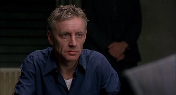 Movie still from “In the Name of the Father” (1993), directed by Jim Sheridan – A person wearing a blue shirt; Close Up shot, Over the shoulder angle