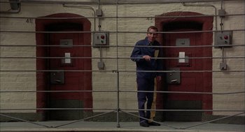Movie still from “In the Name of the Father” (1993), directed by Jim Sheridan – A man standing in front of a jail cell; Wide shot, High angle