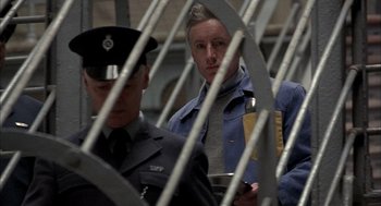 Movie still from “In the Name of the Father” (1993), directed by Jim Sheridan – A man in a blue jacket and a man in a gray suit; Medium shot, High angle