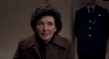 Movie still from “In the Name of the Father” (1993), directed by Jim Sheridan – An older woman wearing a brown coat and a neck tie; Close Up shot, Over the shoulder angle