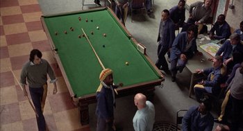 Movie still from “In the Name of the Father” (1993), directed by Jim Sheridan – A group of men standing around a pool table; Wide shot, High angle