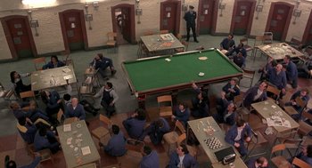 Movie still from “In the Name of the Father” (1993), directed by Jim Sheridan – An overhead view of a group of people sitting around a pool table; Wide shot, High angle