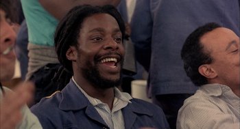 Movie still from “In the Name of the Father” (1993), directed by Jim Sheridan – A man with dreadlocks is smiling for the camera; Close Up shot, Low angle