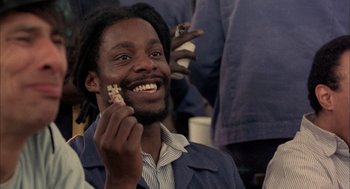 Movie still from “In the Name of the Father” (1993), directed by Jim Sheridan – A man holding a piece of food in his hand; Close Up shot, High angle