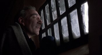 Movie still from “In the Name of the Father” (1993), directed by Jim Sheridan – A person looking out of a window; Close Up shot, Low angle