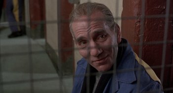 Movie still from “In the Name of the Father” (1993), directed by Jim Sheridan – An older man in a blue jacket looking out a window; Close Up shot, Low angle