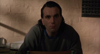 Movie still from “In the Name of the Father” (1993), directed by Jim Sheridan – A man sitting in a chair wearing a sweatshirt; Close Up shot, Low angle