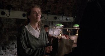 Movie still from “In the Name of the Father” (1993), directed by Jim Sheridan – A woman is holding a bag in her hands; Medium shot, Over the shoulder angle