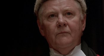 Movie still from “In the Name of the Father” (1993), directed by Jim Sheridan – An older man wearing a white shirt and a white hat; Close Up shot, Low angle