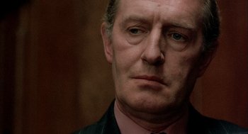 Movie still from “In the Name of the Father” (1993), directed by Jim Sheridan – A person wearing a suit and tie; Close Up shot, Over the shoulder angle