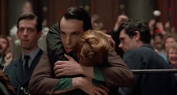 Movie still from “In the Name of the Father” (1993), directed by Jim Sheridan – A man and a woman hugging in a crowded room; Close Up shot, Over the shoulder angle