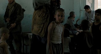 Movie still from “Incendies” (2010), directed by Denis Villeneuve – A young boy is getting his hair combed by an adult; Medium shot, Over the shoulder angle