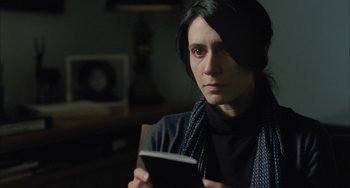 Movie still from “Incendies” (2010), directed by Denis Villeneuve – A woman is holding a book in her hands; Close Up shot, Over the shoulder angle