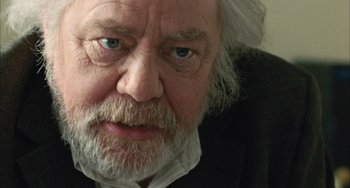 Movie still from “Incendies” (2010), directed by Denis Villeneuve – An older man with a beard and a white beard; Close Up shot, Over the shoulder angle