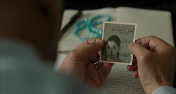 Movie still from “Incendies” (2010), directed by Denis Villeneuve – A person holding a picture of a young man; Extreme Close Up shot, Over the shoulder angle