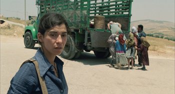 Movie still from “Incendies” (2010), directed by Denis Villeneuve – A woman standing in front of a green truck; Close Up shot, High angle