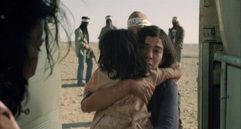 Movie still from “Incendies” (2010), directed by Denis Villeneuve – A woman hugging a young girl in front of a group of people; Close Up shot, Over the shoulder angle