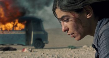 Movie still from “Incendies” (2010), directed by Denis Villeneuve – A person near a car on a dirt road; Close Up shot, Low angle