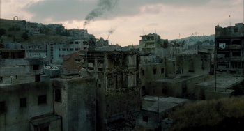 Movie still from “Incendies” (2010), directed by Denis Villeneuve – A view of an urban area with buildings and a smoke stack; Extreme Wide shot, High angle
