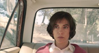 Movie still from “Incendies” (2010), directed by Denis Villeneuve – A woman sitting in the back seat of a car looking out the window; Close Up shot, High angle