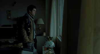Movie still from “Incendies” (2010), directed by Denis Villeneuve – A man standing in front of a window looking outside; Medium shot, Low angle