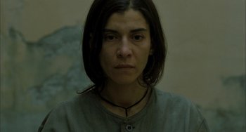 Movie still from “Incendies” (2010), directed by Denis Villeneuve – A person wearing a necklace; Close Up shot, High angle