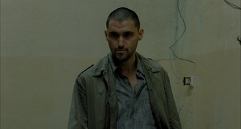 Movie still from “Incendies” (2010), directed by Denis Villeneuve – A person wearing a shirt and jacket; Close Up shot, Low angle