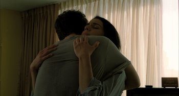 Movie still from “Incendies” (2010), directed by Denis Villeneuve – A man and a woman hugging in front of a window; Close Up shot, Low angle