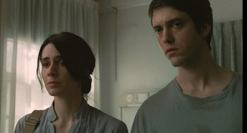 Movie still from “Incendies” (2010), directed by Denis Villeneuve – A man and a woman standing next to each other in a room; Close Up shot, Low angle