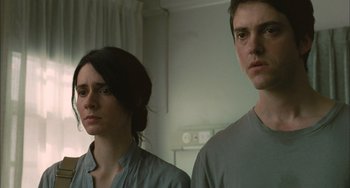 Movie still from “Incendies” (2010), directed by Denis Villeneuve – A man and a woman standing next to each other in a room; Close Up shot, Low angle