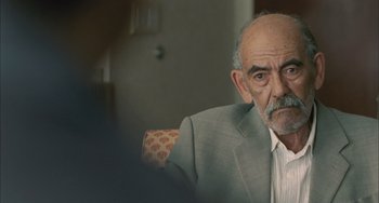 Movie still from “Incendies” (2010), directed by Denis Villeneuve – An older man wearing a suit sitting in front of a mirror; Close Up shot, Over the shoulder angle
