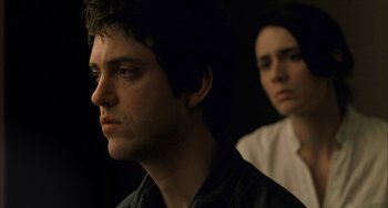 A man and a woman sitting next to each other in a dark room