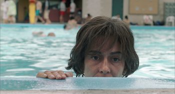 Movie still from “Incendies” (2010), directed by Denis Villeneuve – A man with long hair in a swimming pool; Close Up shot, High angle