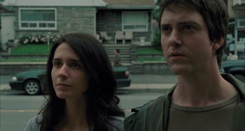 Movie still from “Incendies” (2010), directed by Denis Villeneuve – A man and a woman standing next to each other on the street; Close Up shot, Low angle