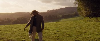 Movie still from “Far from the Madding Crowd” (2015), directed by Thomas Vinterberg – A man walking in the grass with a hat on; Wide shot, Low angle