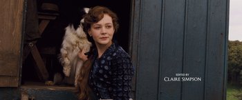 Movie still from “Far from the Madding Crowd” (2015), directed by Thomas Vinterberg – A woman standing in front of a door with a cat; Medium shot, Low angle
