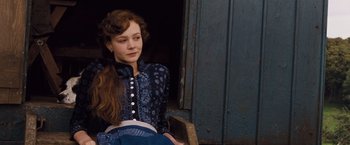 Movie still from “Far from the Madding Crowd” (2015), directed by Thomas Vinterberg – A woman sitting in front of an old door; Medium shot, Over the shoulder angle