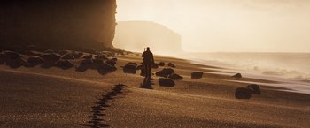 Movie still from “Far from the Madding Crowd” (2015), directed by Thomas Vinterberg – A person walking on the beach near the water; Extreme Wide shot, Low angle