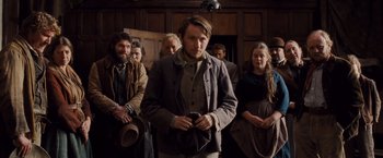 Movie still from “Far from the Madding Crowd” (2015), directed by Thomas Vinterberg – A group of people standing in front of a door; Medium shot, Low angle