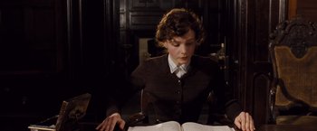 Movie still from “Far from the Madding Crowd” (2015), directed by Thomas Vinterberg – A woman sitting in front of an open book; Medium shot, High angle