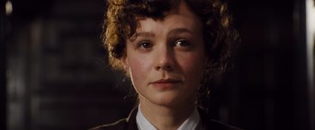 Movie still from “Far from the Madding Crowd” (2015), directed by Thomas Vinterberg – A woman with curly hair and a white shirt is staring straight ahead; Close Up shot, Low angle