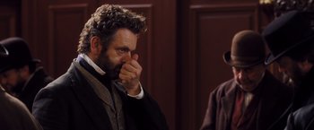 Movie still from “Far from the Madding Crowd” (2015), directed by Thomas Vinterberg – A man in a suit and tie holding his hand to his face; Close Up shot, Over the shoulder angle