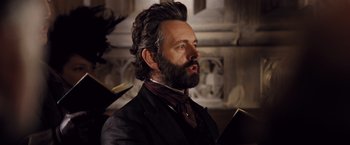 Movie still from “Far from the Madding Crowd” (2015), directed by Thomas Vinterberg – A man with long hair and a goatee wearing a suit; Close Up shot, Over the shoulder angle