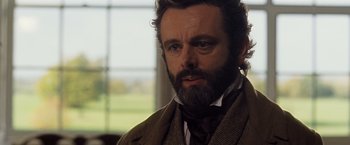 Movie still from “Far from the Madding Crowd” (2015), directed by Thomas Vinterberg – A person wearing a suit and tie; Close Up shot, Over the shoulder angle